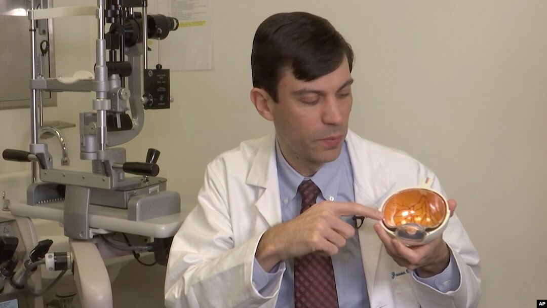 Dr. Jason Comander, inherited retinal disorder specialist at Massachusetts Eye and Ear Infirmary in Boston points to a model of an eye during an interview on Jan. 8, 2020. Comander's hospital plans to enroll patients in a gene editing treatment for blindn