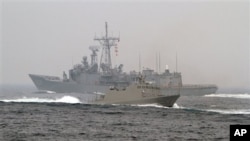 台灣海軍“光華-6”型導彈快艇（前）在高雄附近海域舉行的演習期間從一艘佩里級護衛艦旁駛過。（2013年1月22日）
