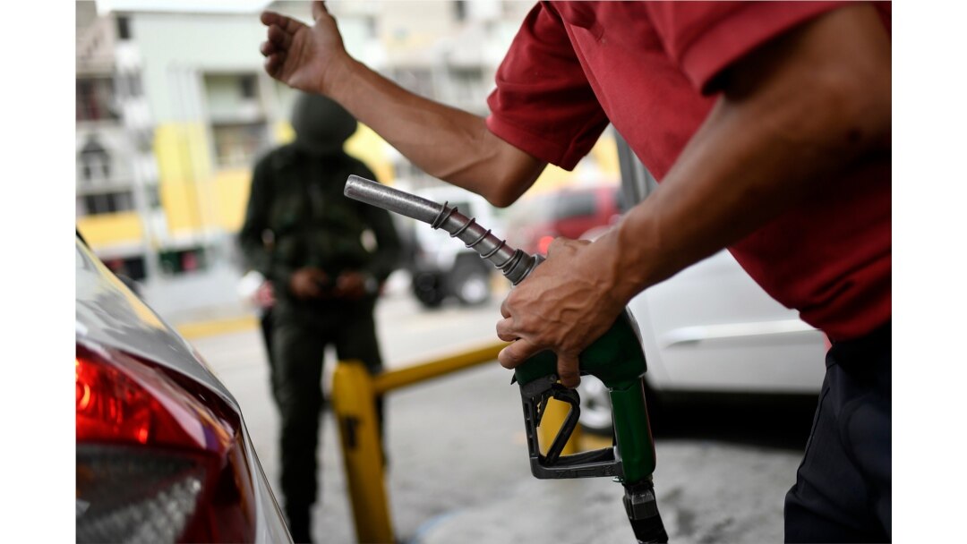 Un trabajador sostiene una bomba de gasolina en una estación de servicio de la compañía petrolera estatal PDVSA en Caracas, Venezuela, el lunes 25 de mayo/2020.