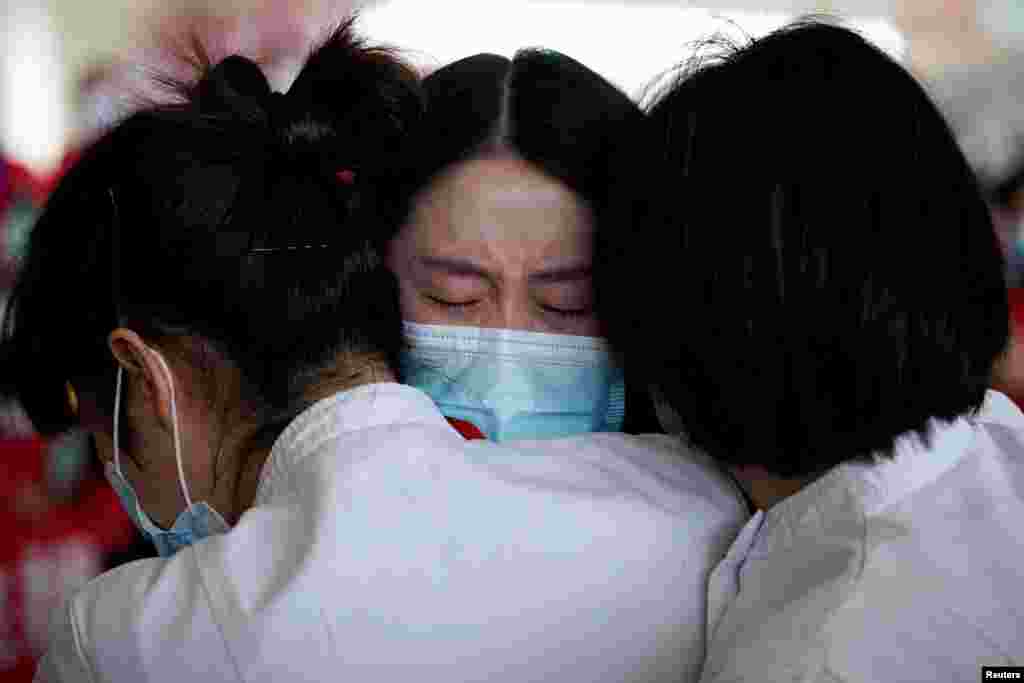 Medical workers hug at the Wuhan Tianhe International Airport after travel restrictions to leave Wuhan, the capital of Hubei province and China's epicentre of the novel coronavirus disease (COVID-19) outbreak, were lifted.