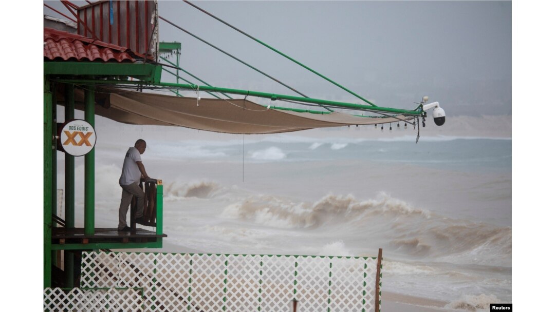 A man looks at the waves of the sea before the arrival of tropical storm Ileana, in Cabo San Lucas, Baja California Sur state, Mexico, Sept. 13, 2024.