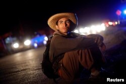 Cristian Israel, un migrante centroamericano que viaja a EE.UU. para pedir asilo, espera a que algún conductor lo lleve más adelante en su jornada tras descansar en un campamento en Matías Romero Avendaño, México. Nov. 10 de 2018.