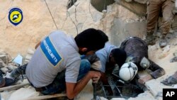 El grupo de Defensa Civil sirio conocido como los Cascos Blancos y los trabajadores de Defensa Civil siria buscan personas en Aleppo al este de Siria después de un ataque aéreo.