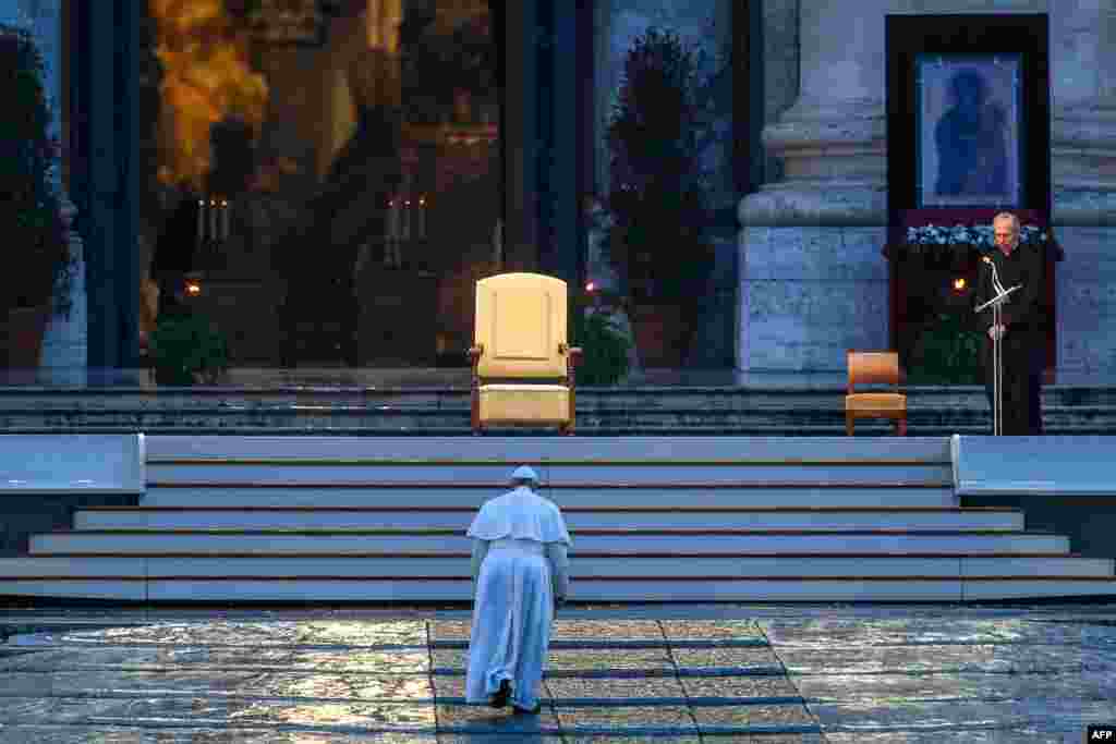 Pope Francis walks toward the platform to preside over a moment of prayer on the sagrato of St Peter's Basilica, at the Vatican.