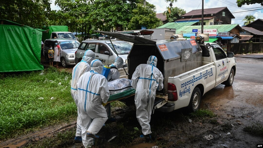Volunteers wearing personal protective equipment (PPE) prepare to transport the body of a victim of the Covid-19 coronavirus to a cemetery in Hlegu Township in Yangon on July 10, 2021. (Photo by Ye Aung THU / AFP)
