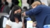 FILE - A woman receives a coronavirus vaccination at Jordan Downs in Los Angeles, California, March 10, 2021. 