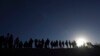 ARCHIVO - Migrantes se encuentran en el lado mexicano de la frontera entre Estados Unidos y México, a orillas del Río Grande, en Ciudad Juárez, México, el 29 de marzo de 2023.