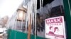 A sign advises patrons of COVID-19 restrictions while long icicles grow from an awning outside a restaurant Feb. 2, 2022, in Denver. 