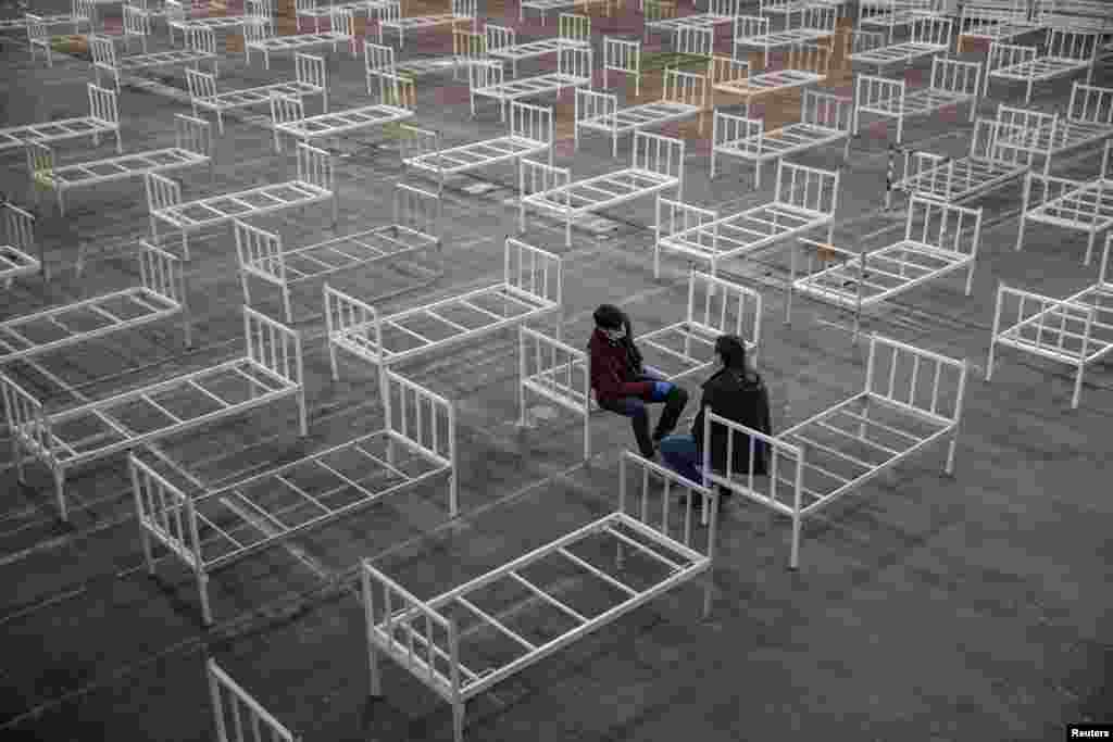 Volunteers take a break as they set up beds inside the Novi Sad Fair to accommodate people who suffer mild symptoms of coronavirus disease in Novi Sad, Serbia.