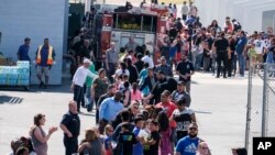 Profesores de la secundaria Cajon reciben a estudiantes de la primaria North Park luego del mortal tiroteo ocurrido en la escuela elemental horas antes. Lunes, 10 de abril de 2017.
