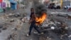 ARCHIVO: Un hombre pasa junto a una barricada en llamas durante una protesta contra el primer ministro haitiano, Ariel Henry, pidiendo su renuncia, en Puerto Príncipe, Haití, el 10 de octubre de 2022.