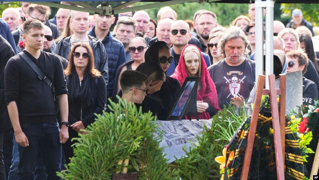 La gente reacciona junto al ataúd del jefe de logística del Grupo Wagner, Valery Chekalov, muerto en el accidente aéreo, durante un funeral en el cementerio Severnoye en San Petersburgo, Rusia, el martes 29 de agosto de 2023.
