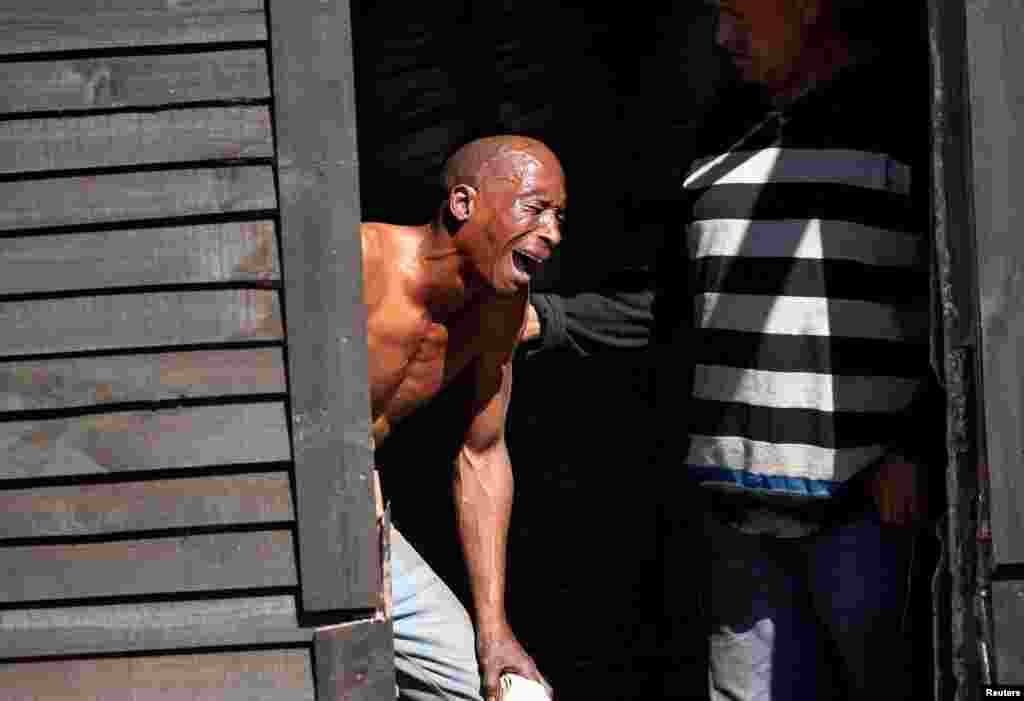A man weeps as law enforcement officials move in to demolish his shack after Khayelitsha township residents attempted to occupy vacant land in Cape Town, South Africa.
