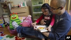 Christopher Astacio reads with his daughter Cristina, 2, who was diagnosed with a mild form of autism. A new study links induced labor with increased risk of autism.