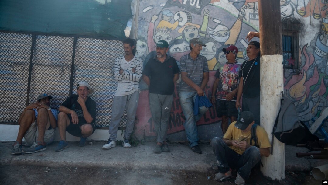 La gente espera una comida afuera de un comedor de beneficencia en las afueras de Buenos Aires, el miércoles 21 de febrero de 2024. Los niveles de pobreza se han disparado en el país. Grupos minoritarios también enfrentan la pobreza y la discriminación.