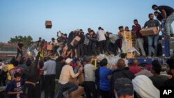 Palestinos tratan de alcanzar ayuda humanitaria en la Franja de Gaza el 18 de mayo del 2024.
