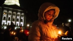 Mourners gather for a candlelight vigil at the Wisconsin State Capitol building a day after a shooting at Abundant Life Christian School, in Madison, Wisconsin, Dec. 17, 2024.