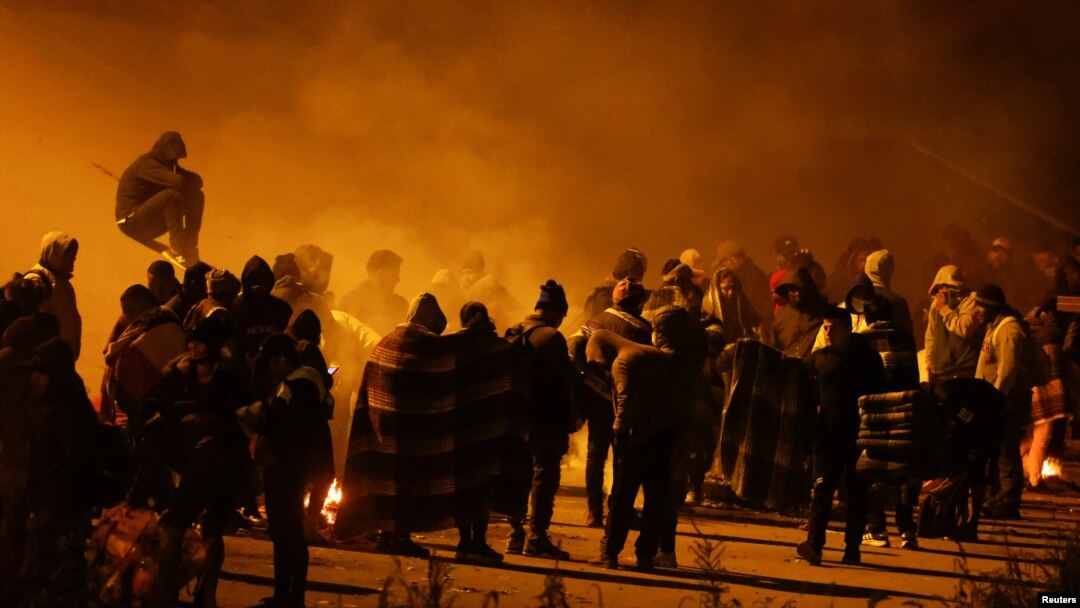 Migrantes esperan cerca del muro fronterizo después de cruzar el Río Grande para entregarse a la Patrulla Fonteriza de EEUU y solicitar asilo en El Paso, Texas, el 19 de diciembre de 2022.