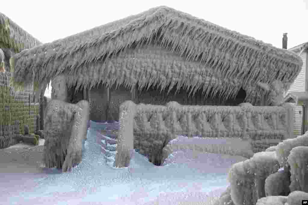 Houses along Hoover Beach is covered by ice from high winds and from the waves from Lake Erie, Feb. 29, 2020, in Hamburg New York. Blowing snow has fallen around the state since Thursday, though the heaviest snowfall was concentrated in largely rural areas east of Lake Erie and Lake Ontario.